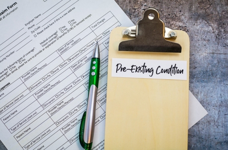 Clipboard featuring pre-existing conditions over an official form