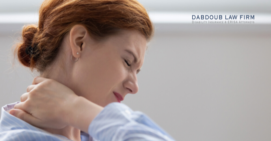 A woman is holding her neck, looking distressed.