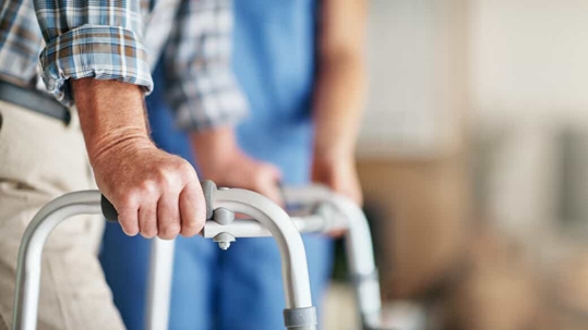 Senior man holds a walker in a nursing home