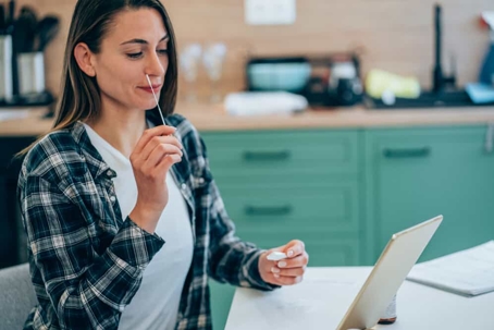 Young woman conducts a nose swab covid test at home