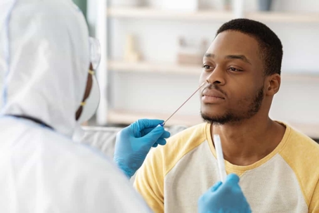 Young man receives a nose swab covid test in a hospital