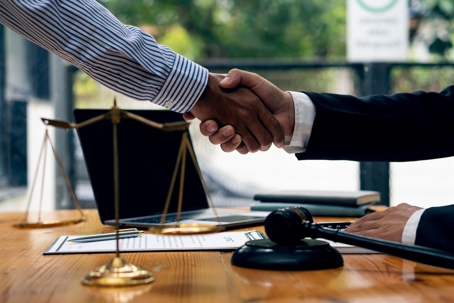 Two businessmen shaking hands in a lawyer's office