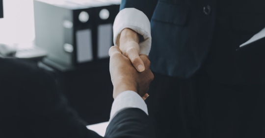 Two men shaking hands after meeting at Dabdoub Law Firm.