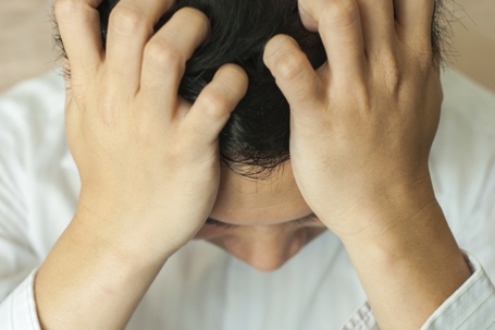 distressed man clutching his head