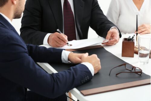 business men signing paperwork